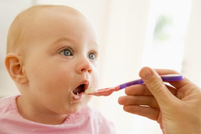 Mother feeding baby first feeding baby